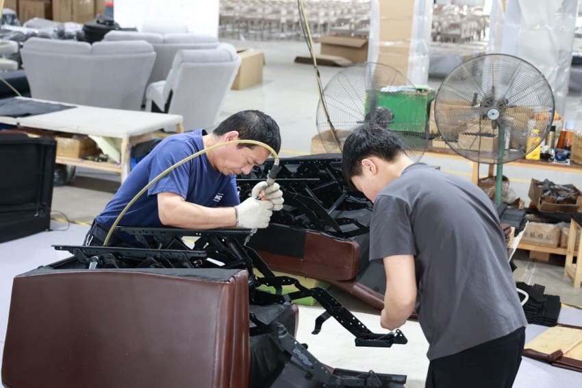 Two men working on furniture in Zen Living Furniture factory.